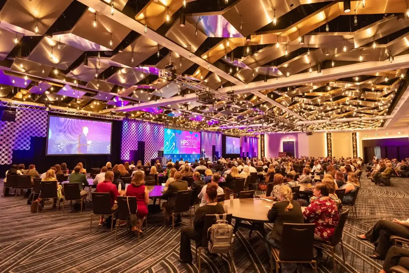 Professional concert stage with dramatic multi-color lighting beams