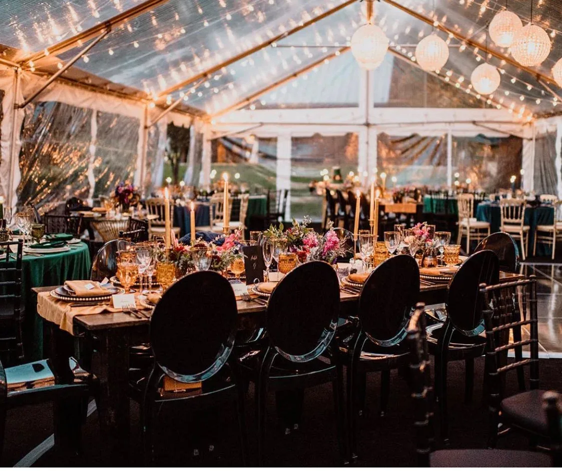Wedding tent reception with string lights and floral tables